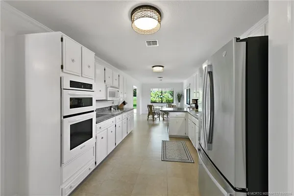 a kitchen with a refrigerator sink and cabinets