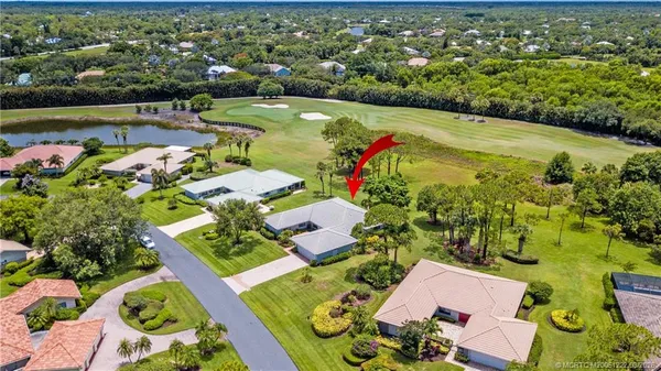 a front view of a house with a yard and potted plants