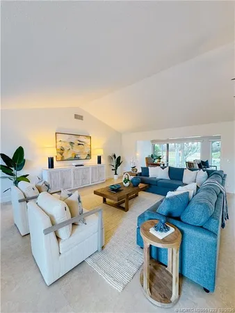 a living room with furniture potted plant and a window