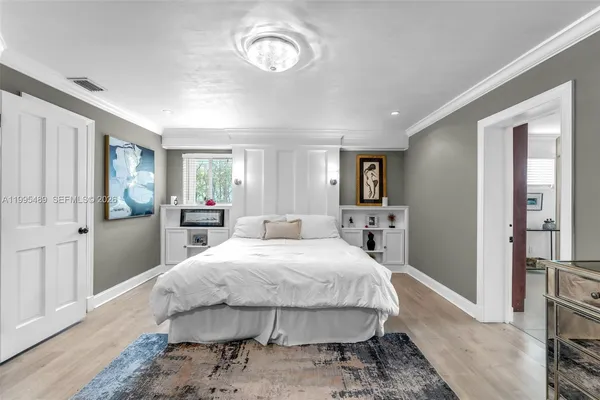 a spacious bedroom with a bed and a flat screen tv
