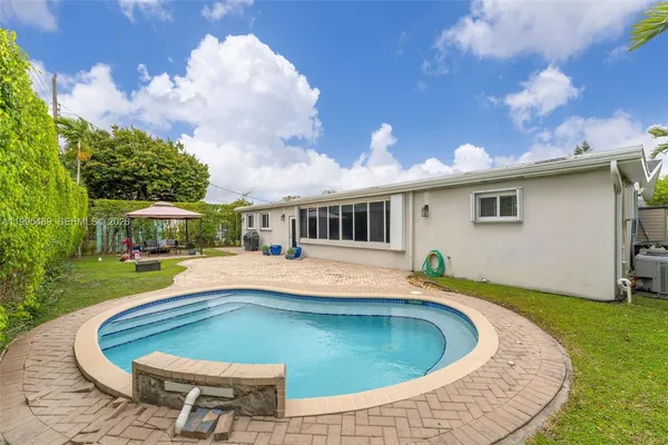 a swimming pool with outdoor seating yard and barbeque oven