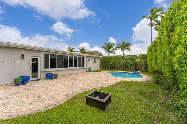 a view of a house with backyard and sitting area