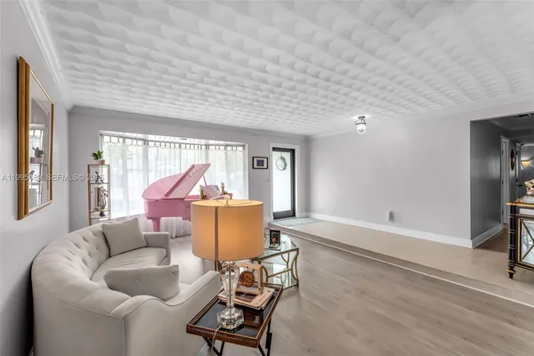 a living room with furniture a large window and a wooden floor