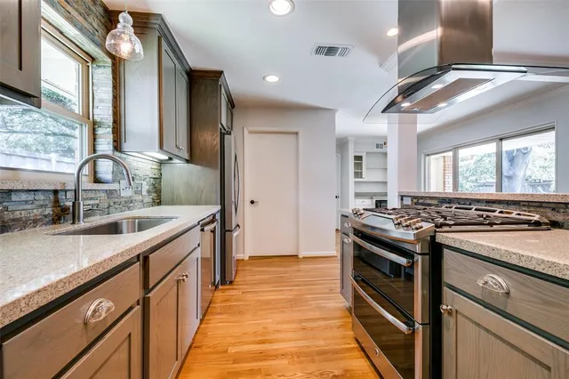 a kitchen with stainless steel appliances granite countertop a stove and a sink