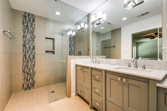 a bathroom with a double vanity sink mirror and shower
