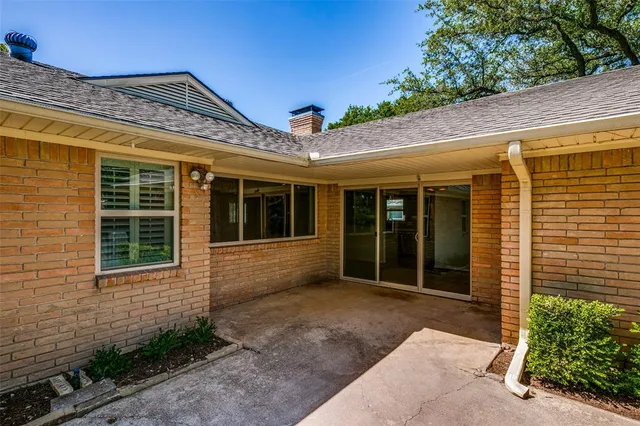 a view of a house with a large window and flower plants