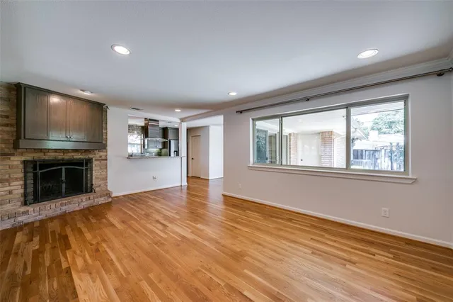 a view of an empty room with a window and fireplace