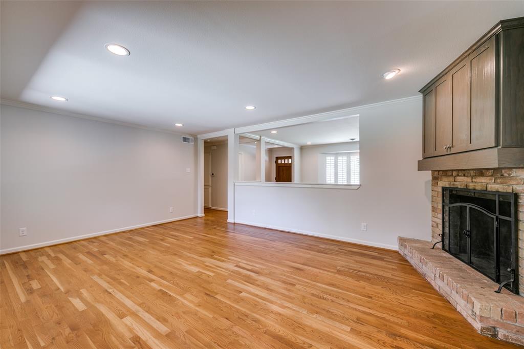 6815 Santa Maria Lane Dallas, TX 75214 - Photo 7 of 24 a view of empty room with wooden floor and fireplace