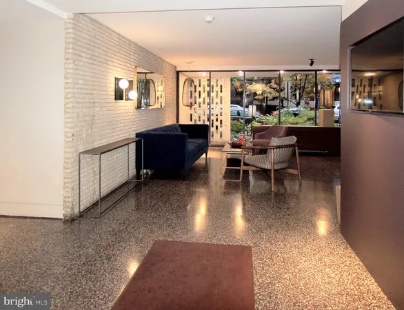 a living room with couches a flat screen tv and kitchen view