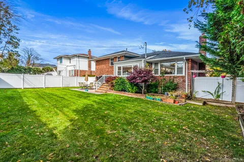 a front view of a house with a garden and plants