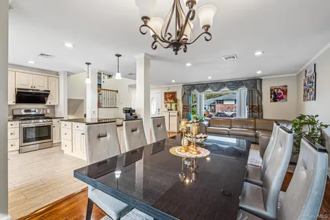 a view of a dining room with furniture a kitchen and chandelier