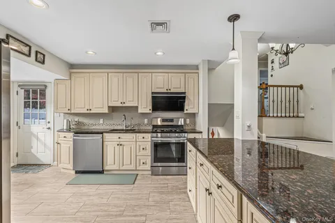 a kitchen with stainless steel appliances granite countertop a stove a sink and a refrigerator