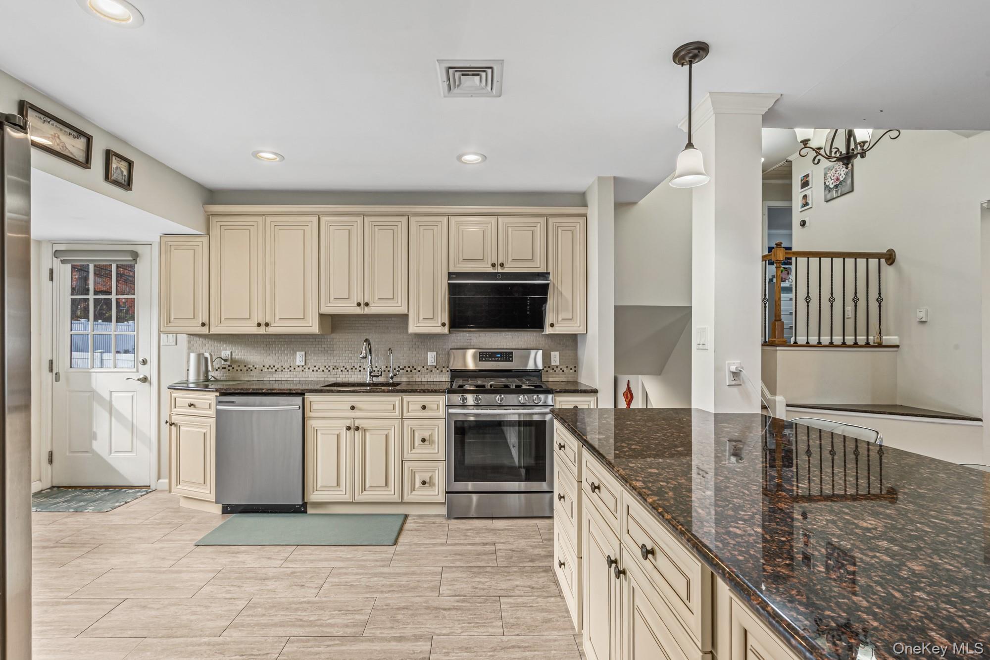 15 Vista Road Plainview, NY 11803 - Photo 9 of 26 a kitchen with stainless steel appliances granite countertop a stove a sink and a refrigerator