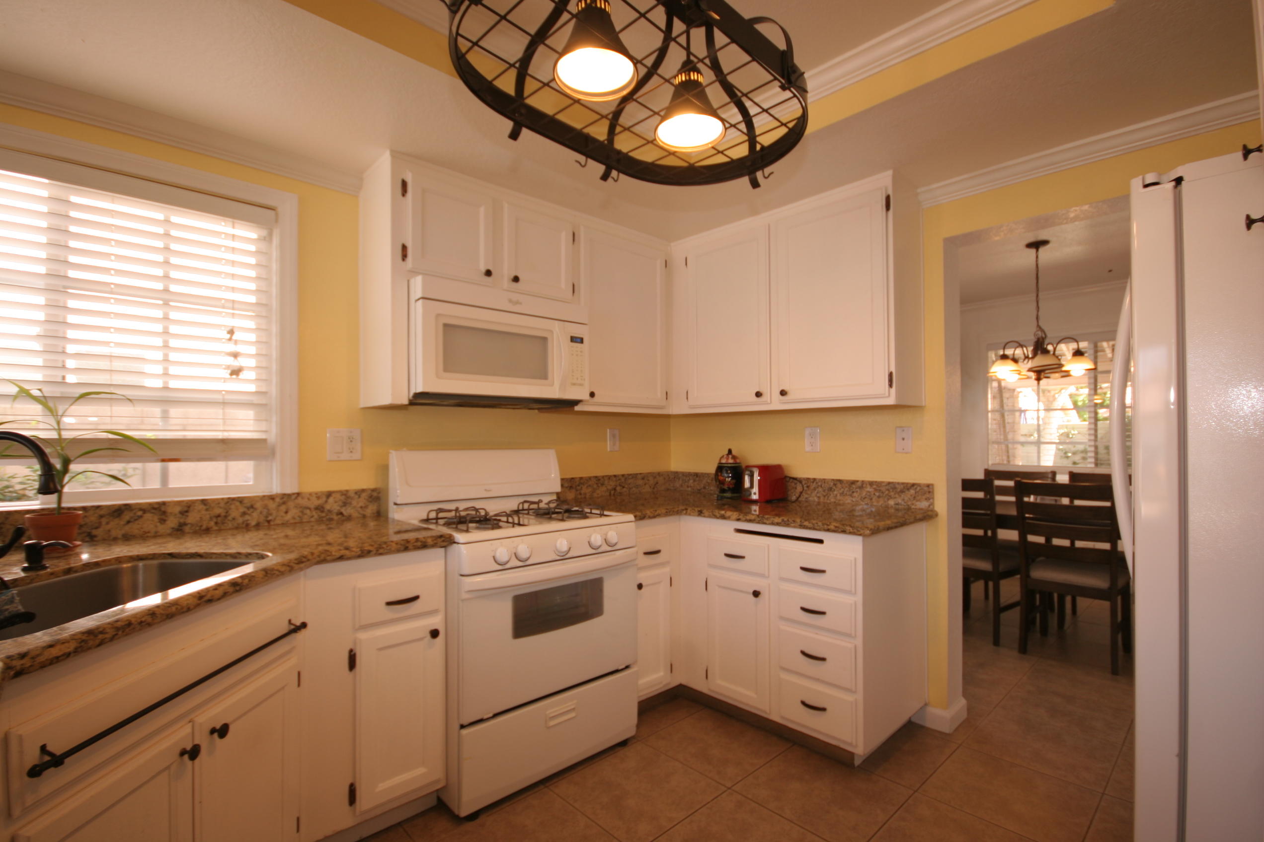 45736 Sutter Creek Road Indio, CA 92201 - Photo 17 of 44 a kitchen with white cabinets and appliances