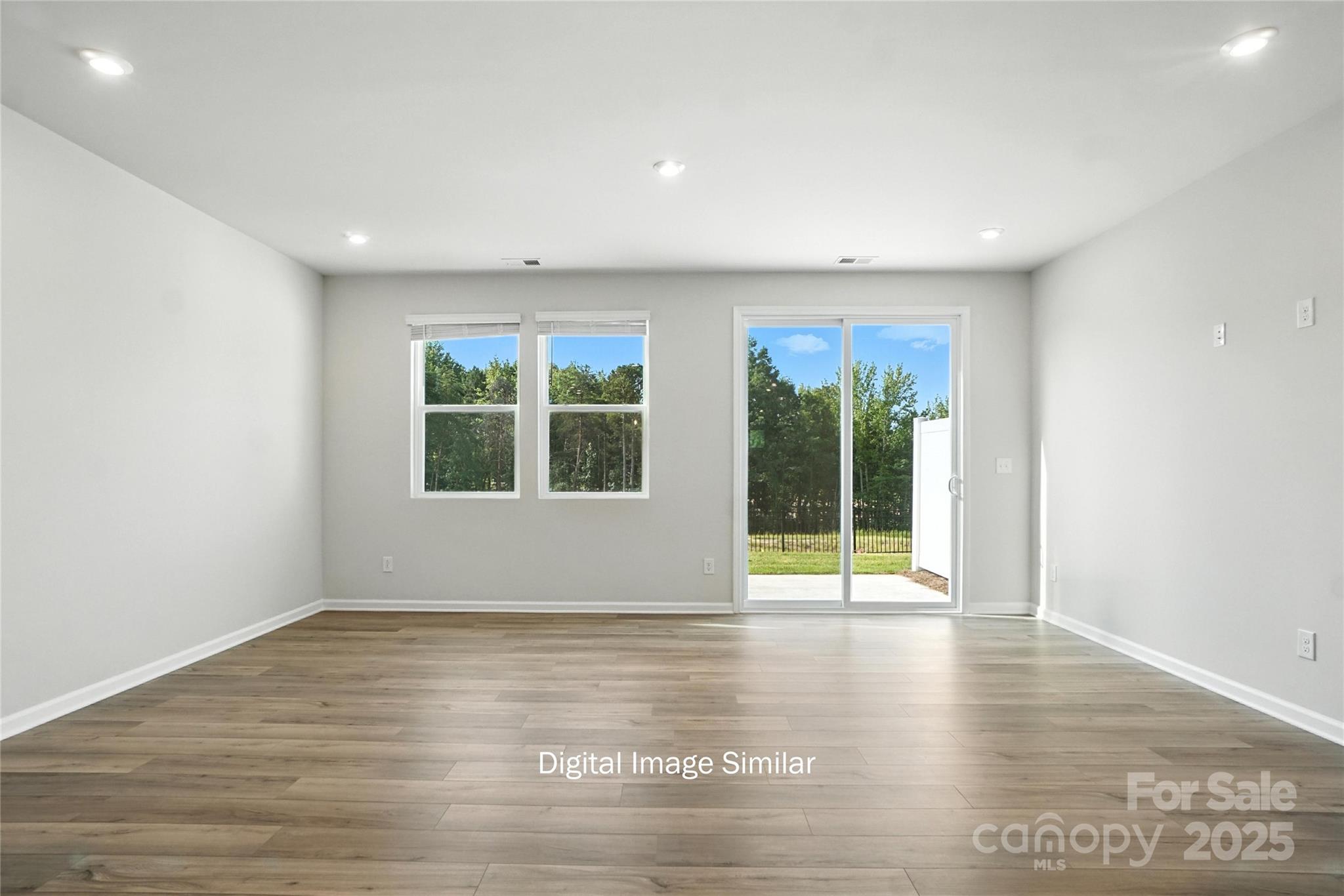 1209 Vibrant Road Charlotte, NC 28215 - Photo 3 of 8 a view of an empty room with wooden floor and a window