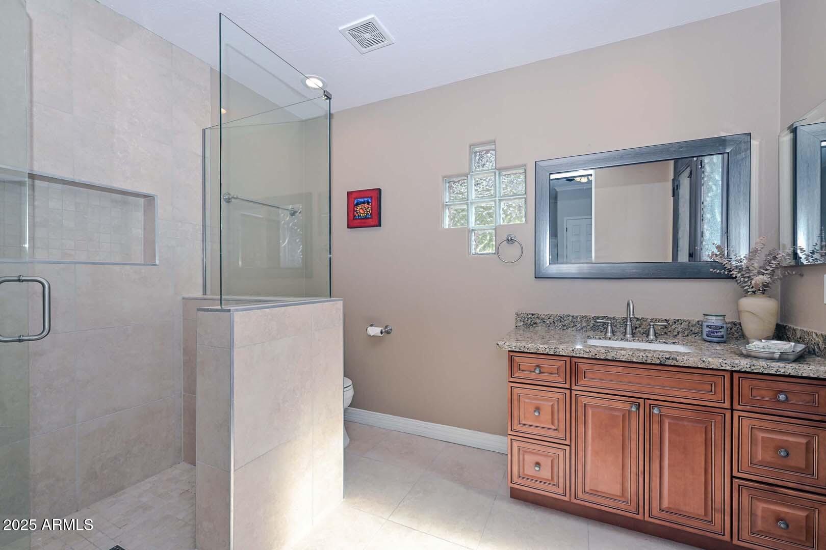 8540 East McDowell Road, Unit 55 Mesa, AZ 85207 - Photo 50 of 111 a bathroom with a granite countertop sink a mirror and a shower