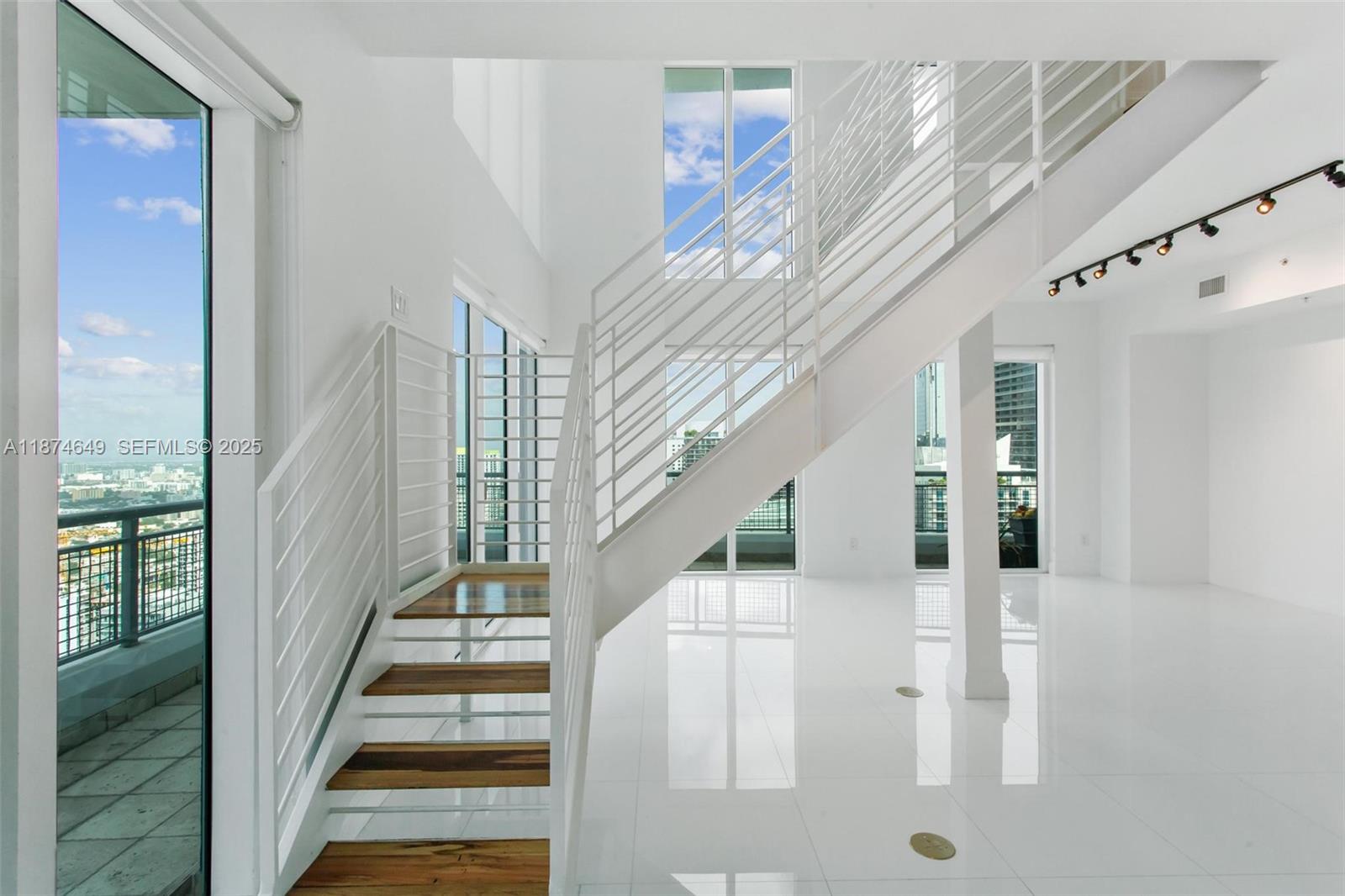 60 Southwest 13th Street, Unit 4413 Miami, FL 33130 - Photo 11 of 41 a view of staircase with lots of frames on wall and windows