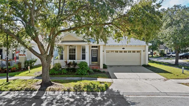 a view of a white house with a yard and potted plants