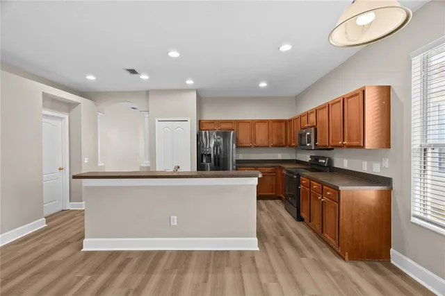 a kitchen with stainless steel appliances granite countertop a stove a sink and a refrigerator