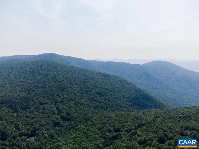a view of a dry yard with mountains in the background