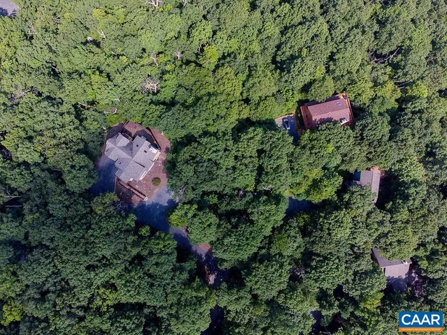 an aerial view of a house with a yard and lake view