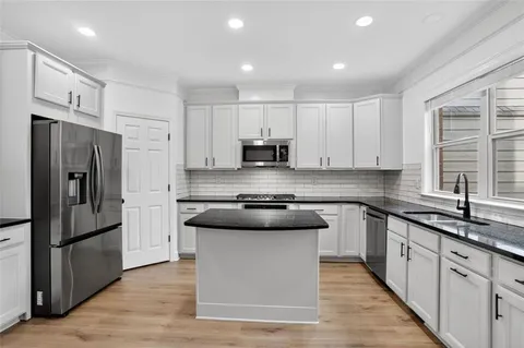 a kitchen with stainless steel appliances granite countertop a stove a sink and a refrigerator