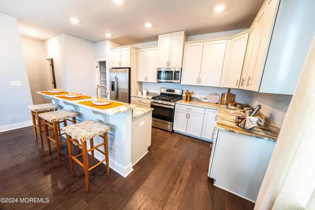 a kitchen with stainless steel appliances a stove a sink a refrigerator and a refrigerator