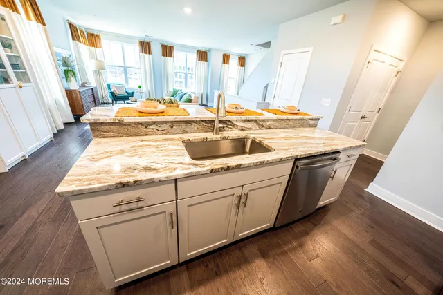 a kitchen with sink and wooden floor