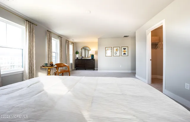 a large bedroom with a bed and large windows