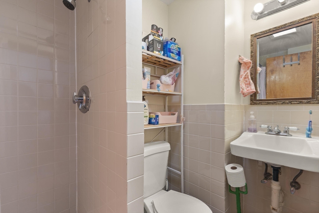 25-27 Upland Road Somerville, MA 02144 - Photo 26 of 38 a bathroom with a toilet a sink and mirror