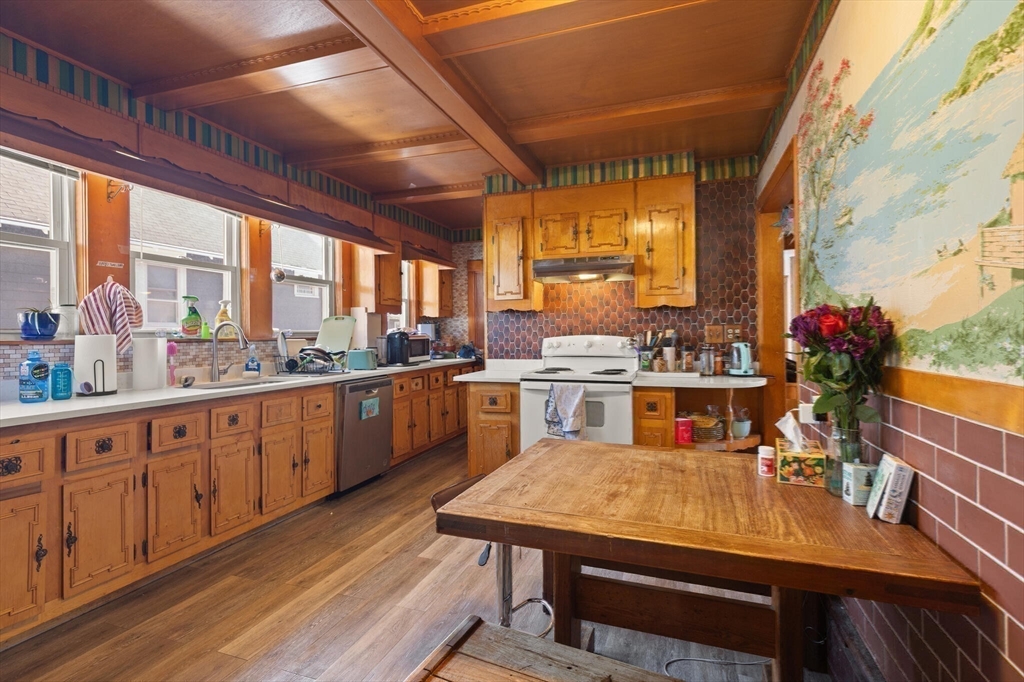 25-27 Upland Road Somerville, MA 02144 - Photo 10 of 38 a kitchen with a table chairs stove and cabinets