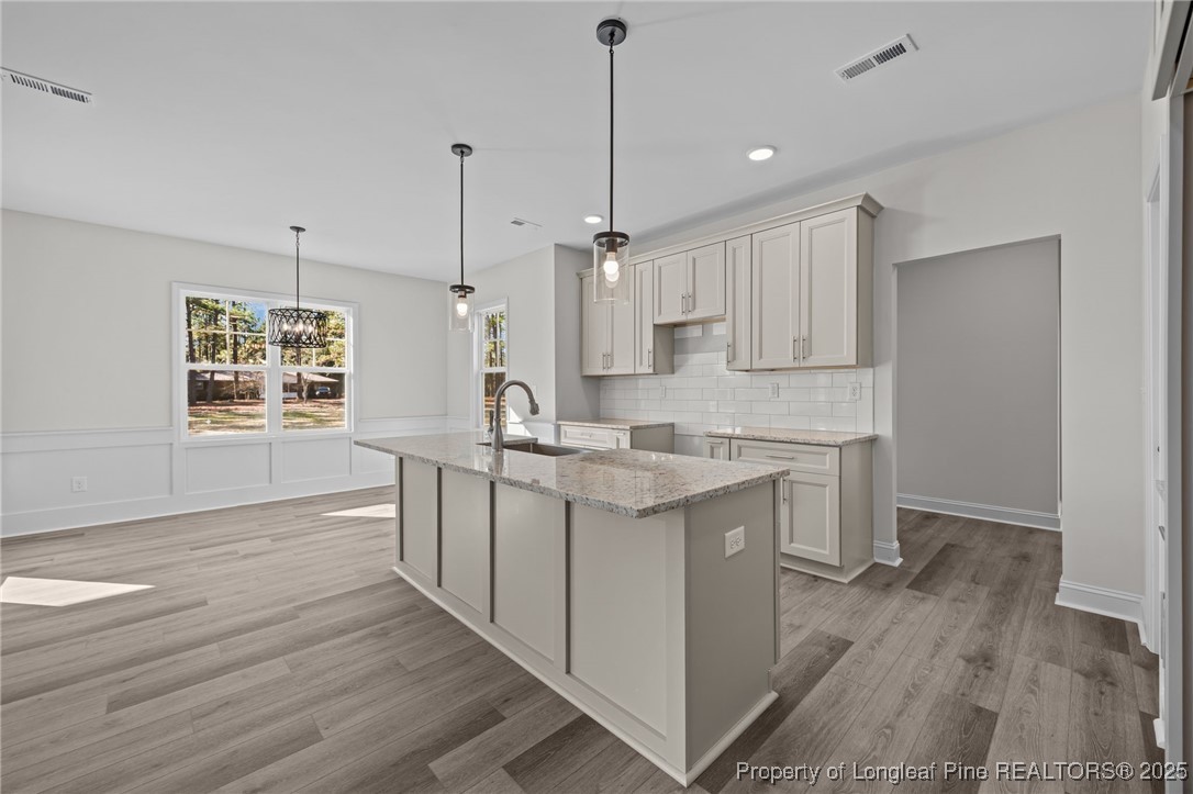 785 Quewhiffle (lot 3) Road Aberdeen, NC 28315 - Photo 16 of 50 a kitchen with stainless steel appliances granite countertop a sink stove and wooden floor