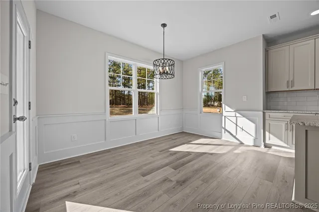 an empty room with windows and ceiling fan