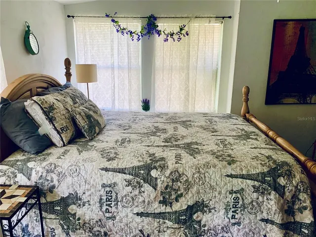 a bed sitting in a spacious bedroom next to a window