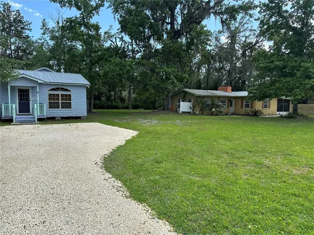 a dining room with furniture a chandelier and wooden floor