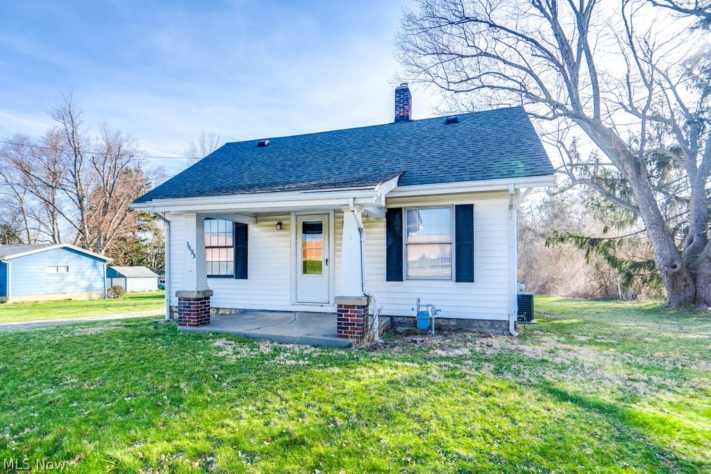 3693 Fishcreek Road Stow, OH 44224 - Photo 2 of 23 Rear view of house featuring central air condition unit and a lawn