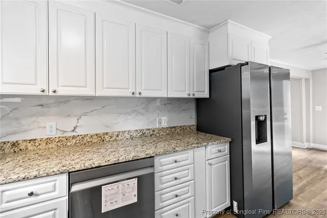 a kitchen with stainless steel appliances granite countertop a refrigerator sink and cabinets