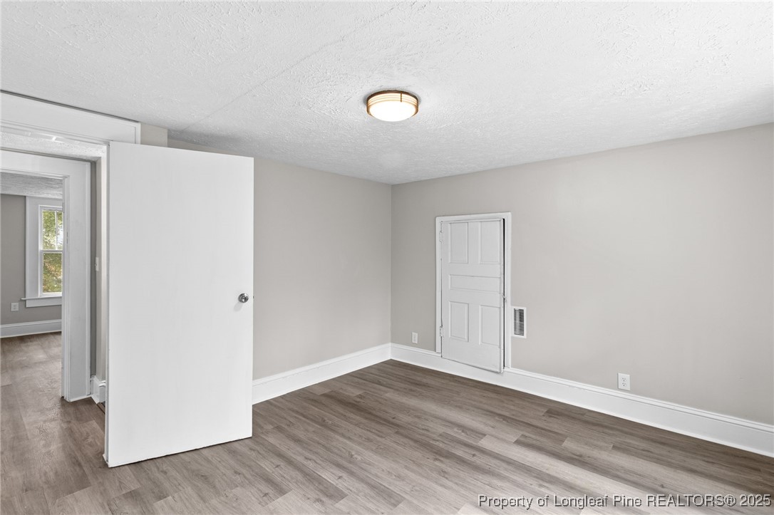 402 Morro Street Fairmont, NC 28340 - Photo 30 of 36 an empty room with wooden floor and windows