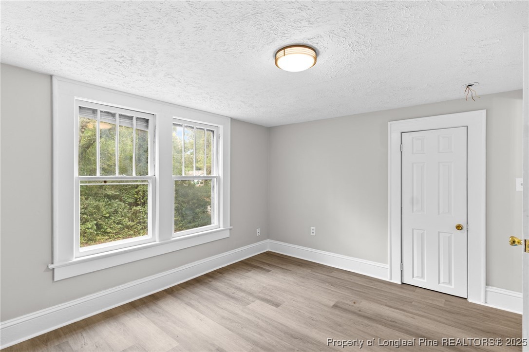 402 Morro Street Fairmont, NC 28340 - Photo 31 of 36 an empty room with wooden floor and windows