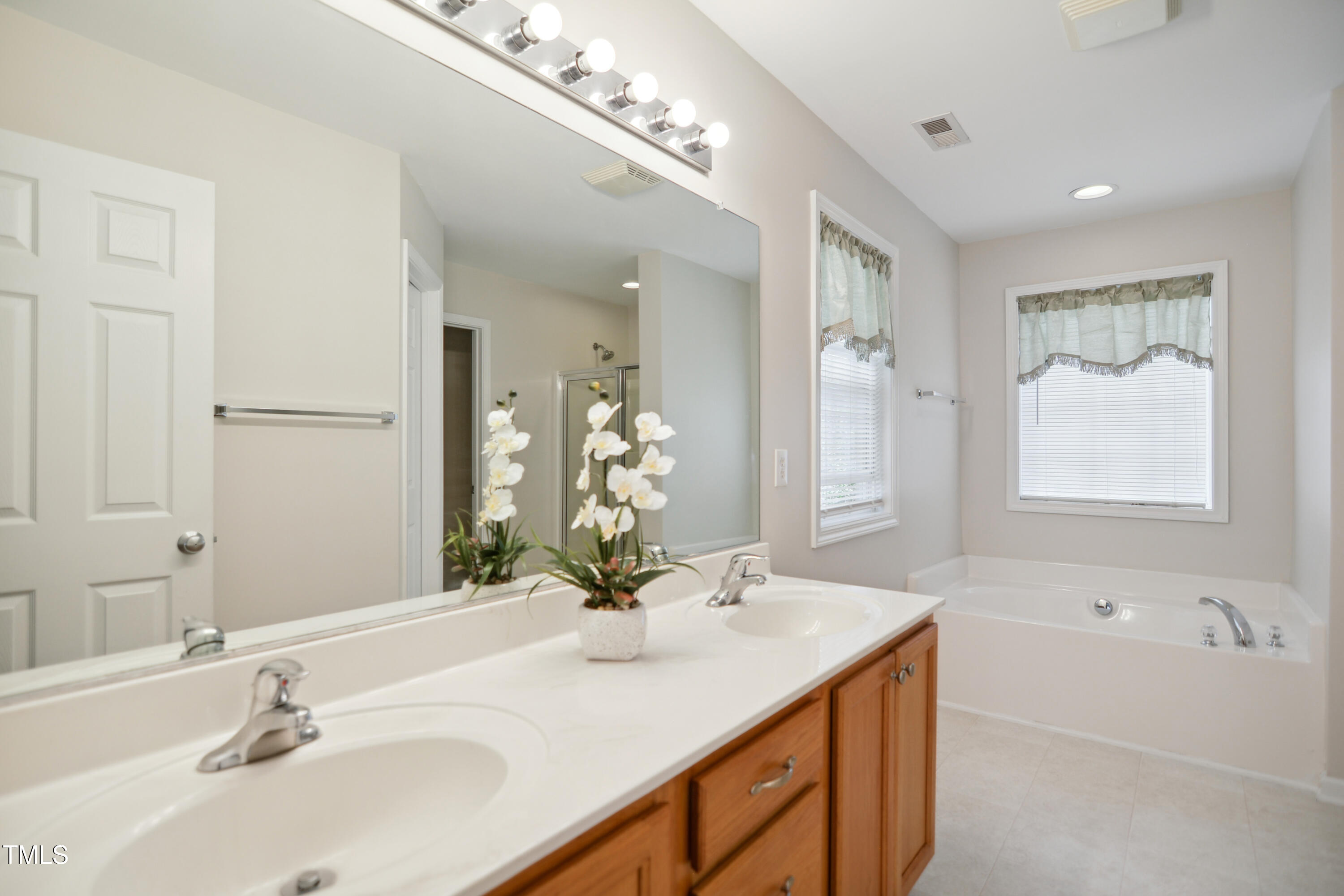 101 Whitney Lane Durham, NC 27713 - Photo 15 of 28 a bathroom with a sink double vanity granite tub shower and a mirror