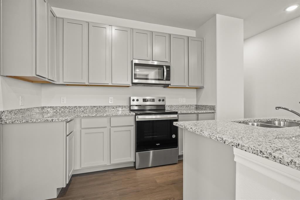 5025 Wellborn Road Crowley, TX 76036 - Photo 2 of 38 a kitchen with granite countertop white cabinets and stainless steel appliances