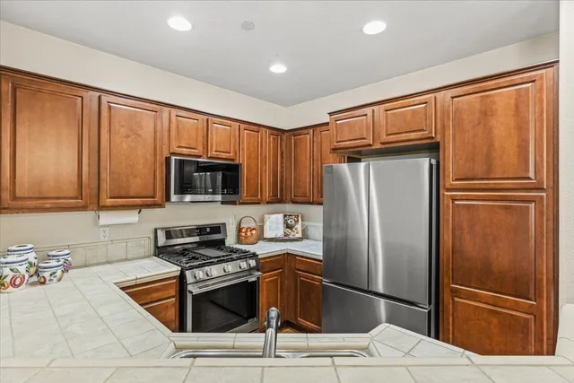 a kitchen with stainless steel appliances granite countertop a refrigerator stove a sink and dishwasher