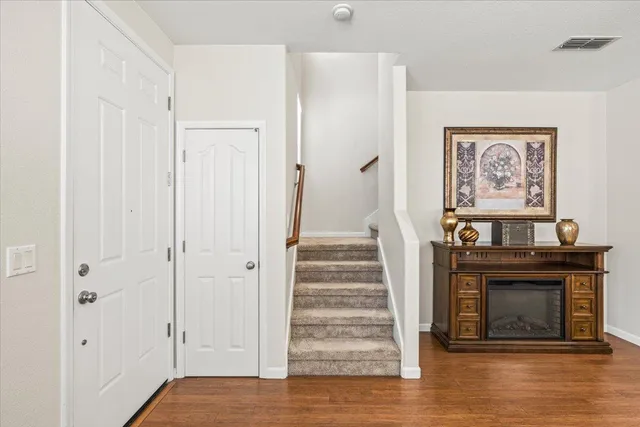 a view of a hallway with wooden floor and a fireplace