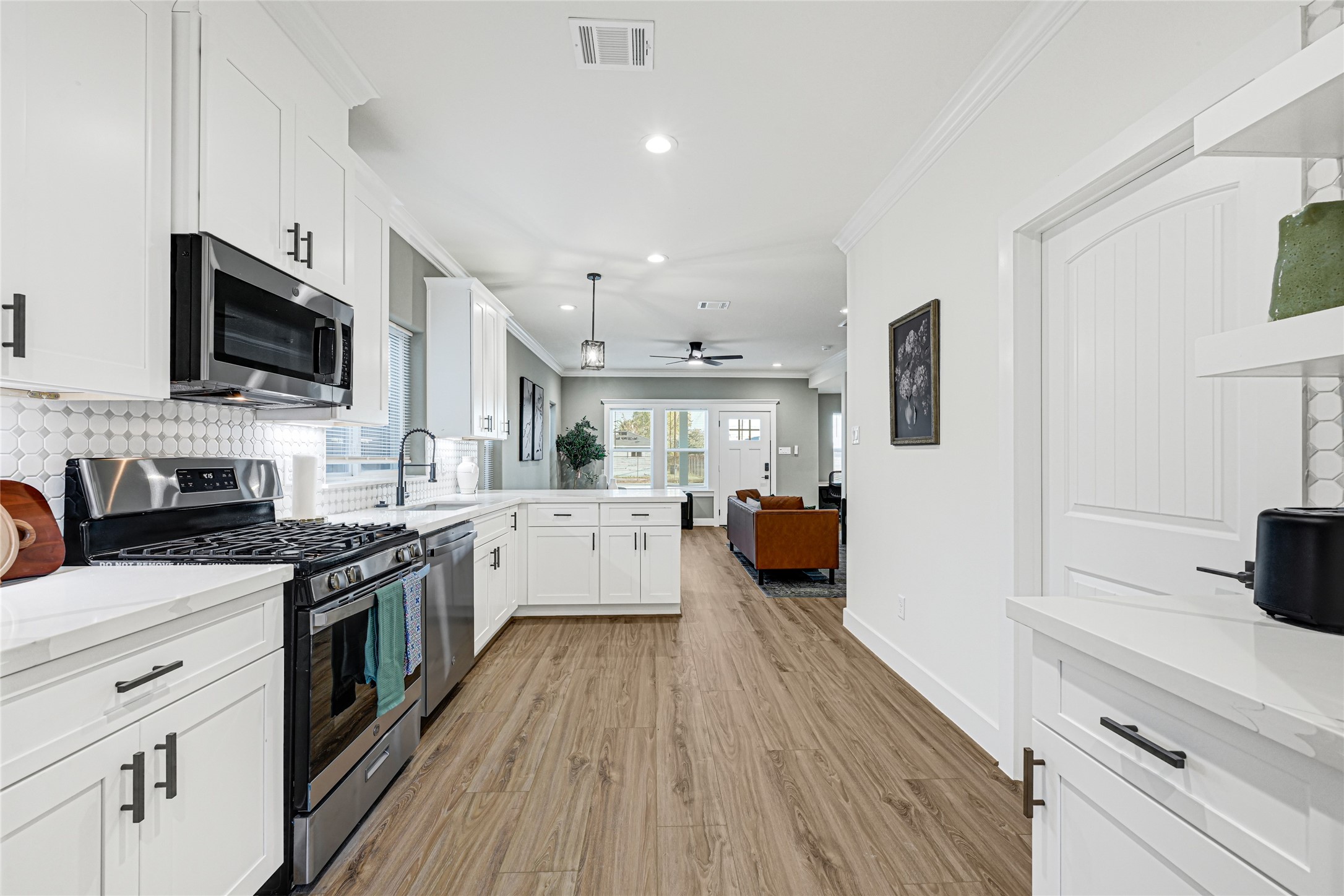 3510 Rebecca Street Houston, TX 77021 - Photo 6 of 28 a kitchen with stainless steel appliances a sink dishwasher a stove top oven a refrigerator with wooden floor and cabinets