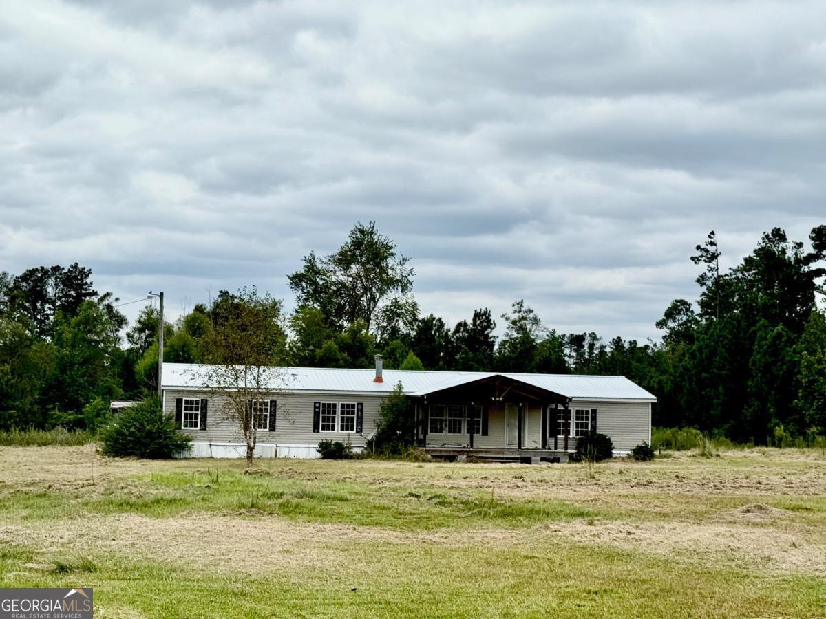 642 Still Road Alamo, GA 30411 - Photo 1 of 21 a white house with a big yard and large trees