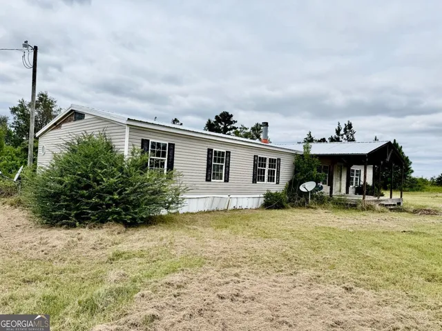 a front view of house with yard and trees around