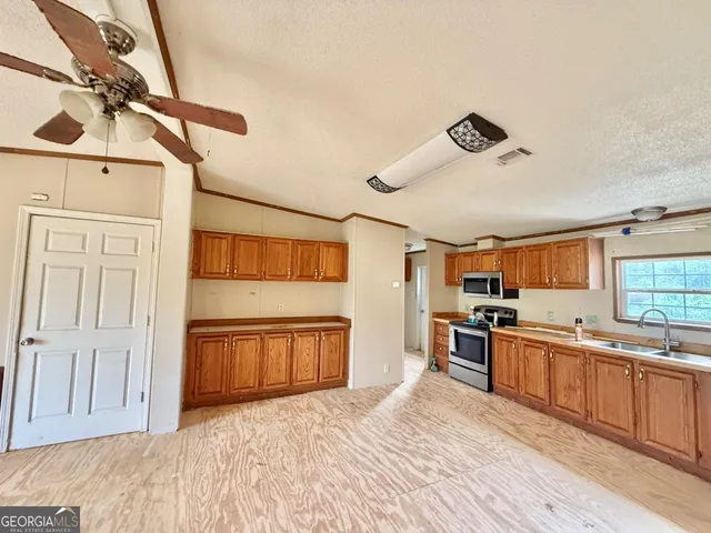 a kitchen with stainless steel appliances granite countertop a sink and cabinets