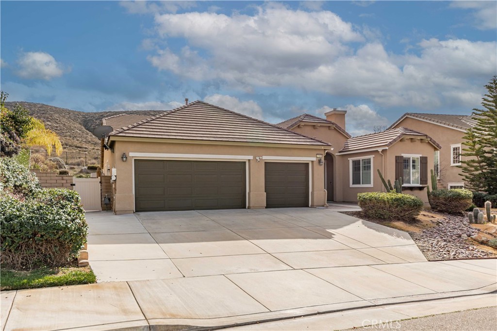 27989 Whittington Road Menifee, CA 92584 - Photo 1 of 1 a front view of a house with a garden and entryway