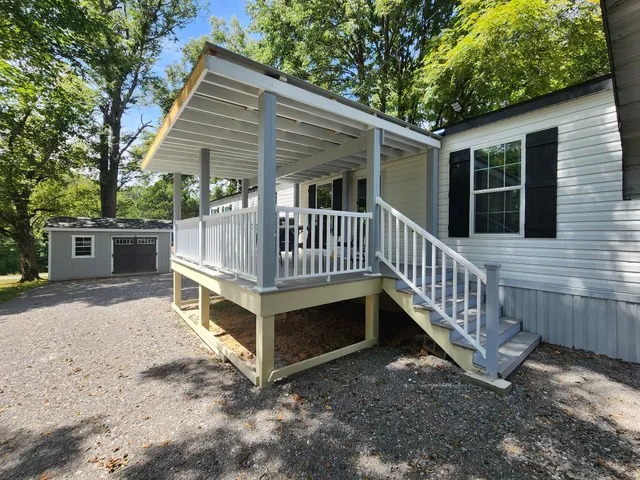 a view of a house with a yard and a deck