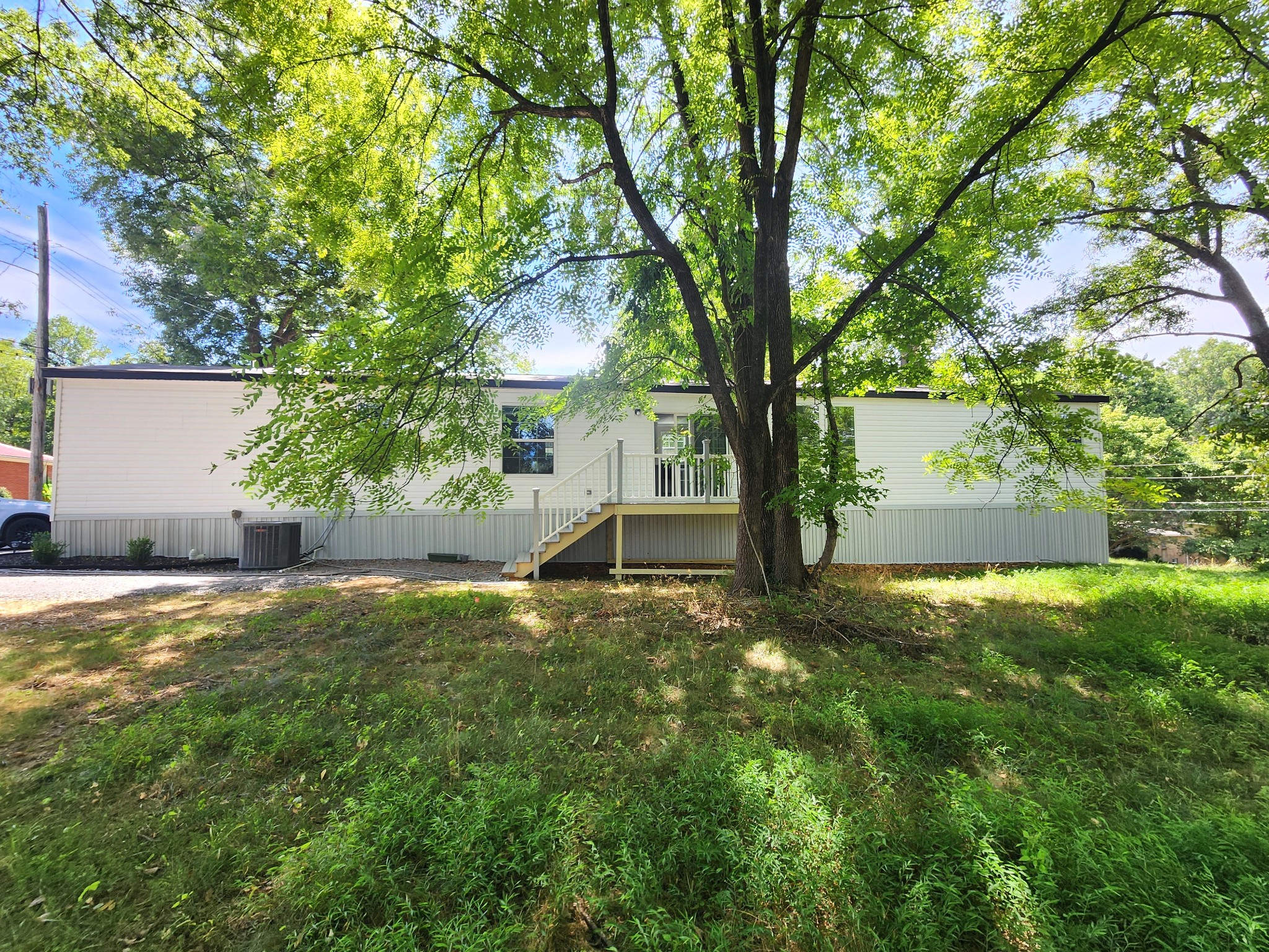23 Yates Street Paris, TN 38242 - Photo 17 of 17 a backyard of a house with plants and large trees